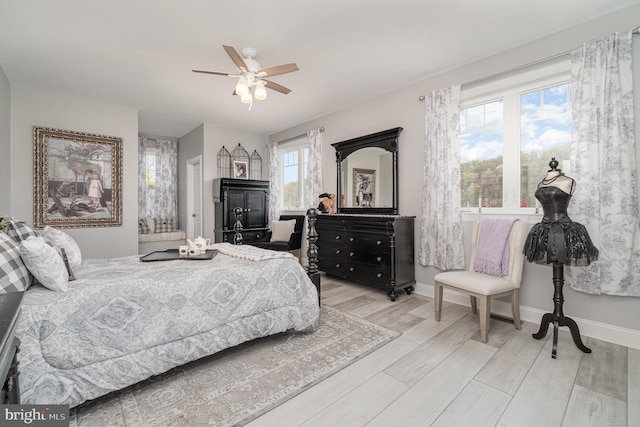 bedroom featuring ceiling fan, light wood finished floors, and baseboards