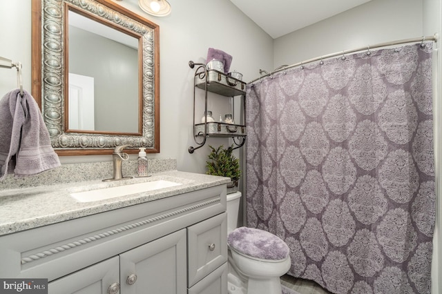 bathroom with a shower with shower curtain, vanity, and toilet