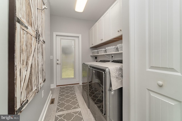 laundry area with cabinet space, visible vents, baseboards, and washer and dryer