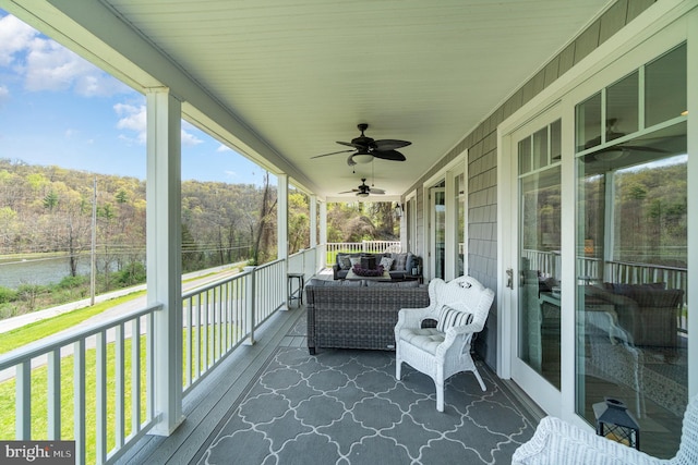 wooden deck featuring a water view and ceiling fan