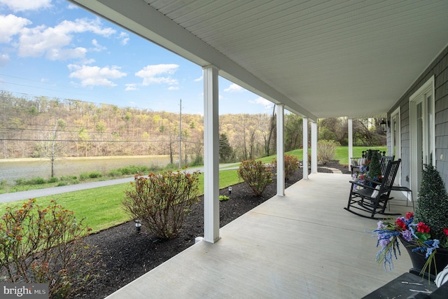 view of patio with a forest view and a porch