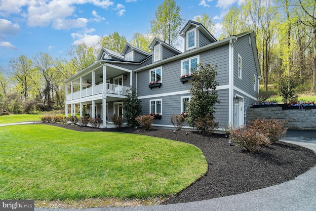 shingle-style home with a front yard and a balcony