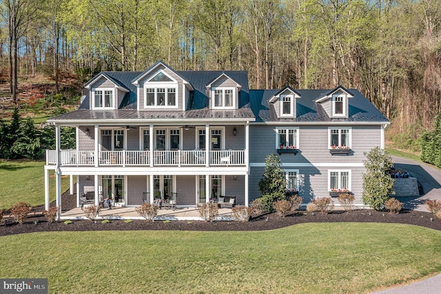 view of front facade with covered porch, a ceiling fan, a front yard, a patio area, and a balcony