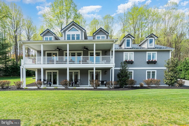 view of front of home with a ceiling fan, a patio area, a balcony, and a front lawn