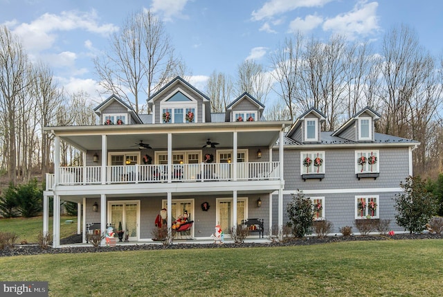 view of front of house featuring covered porch, ceiling fan, a balcony, and a front lawn