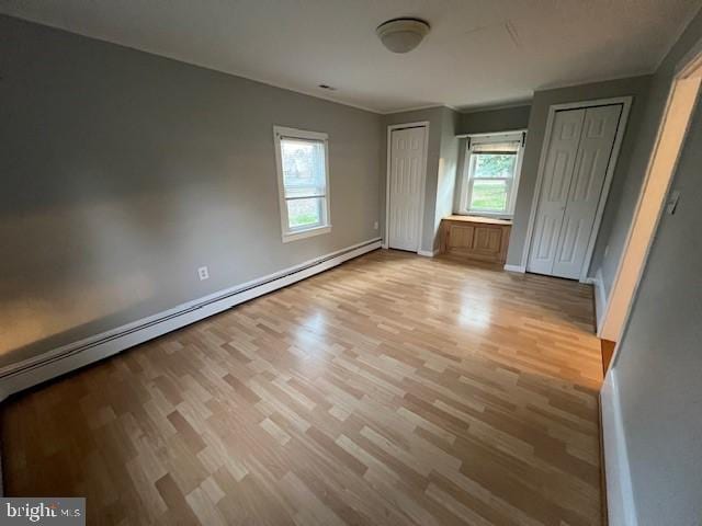 508 Garden Way, Mount Laurel, NJ 08054 - unfurnished bedroom featuring two closets, a baseboard radiator, baseboards, and wood finished floors