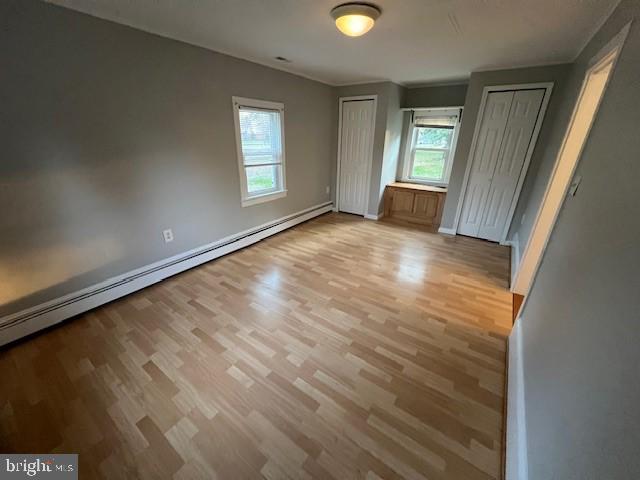 508 Garden Way, Mount Laurel, NJ 08054 - unfurnished bedroom featuring two closets, multiple windows, and wood finished floors