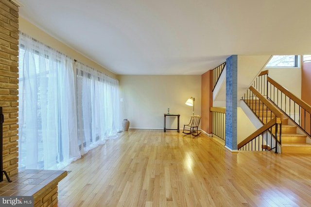 living area with stairway, baseboards, and wood finished floors