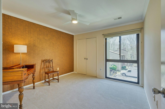 sitting room with visible vents, ornamental molding, a ceiling fan, carpet flooring, and baseboards