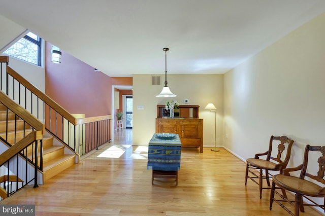 entryway featuring visible vents, stairs, light wood-type flooring, and baseboards