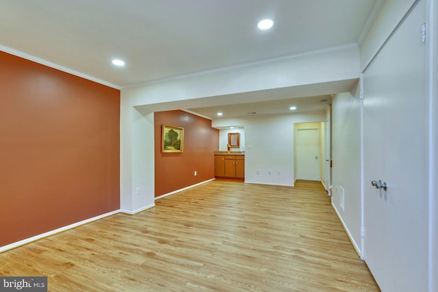 empty room featuring recessed lighting, baseboards, light wood-style floors, and crown molding