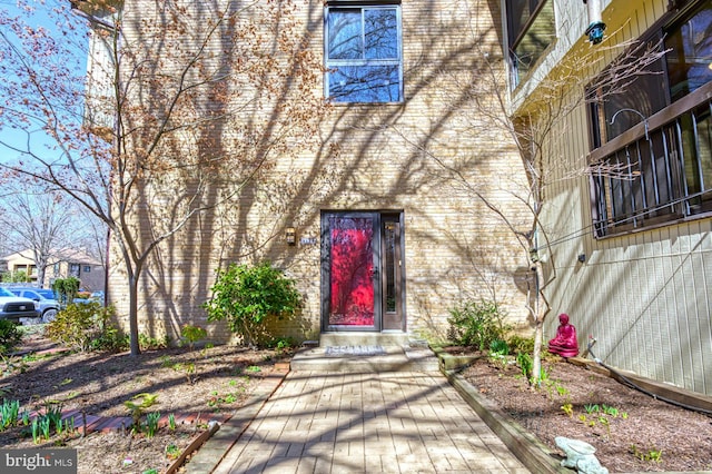 view of exterior entry featuring brick siding