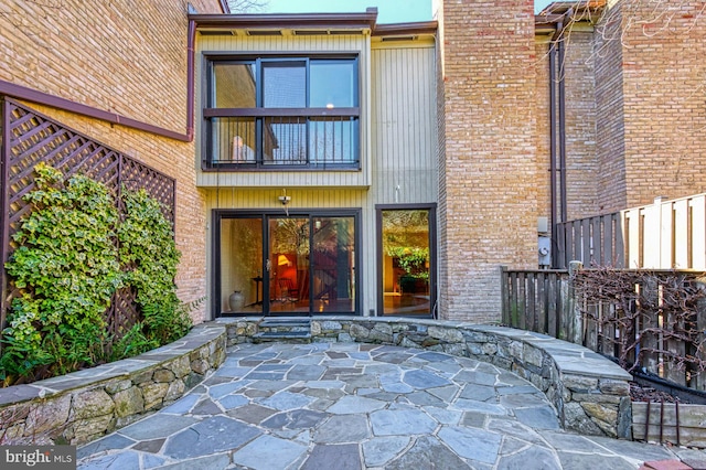 back of property featuring brick siding, a chimney, and a patio area