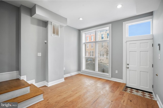 foyer entrance with light wood-type flooring, baseboards, visible vents, and recessed lighting