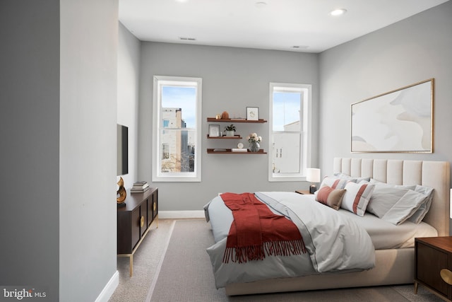 bedroom with light carpet, multiple windows, baseboards, and recessed lighting