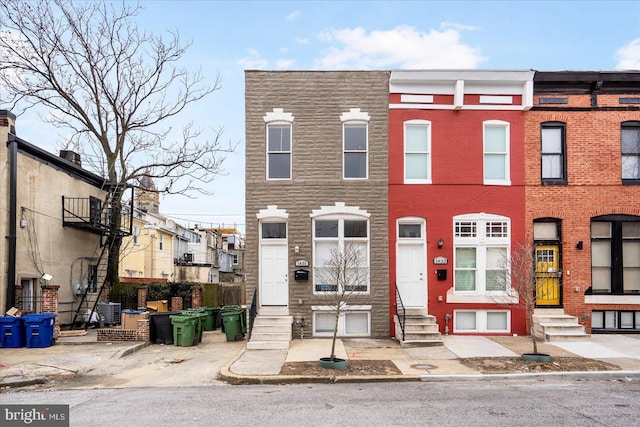 multi unit property featuring entry steps, brick siding, and central AC unit