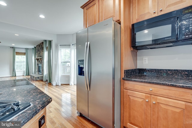 16309 Sandy Ridge Ct, Woodbridge, VA 22191 - kitchen with appliances with stainless steel finishes, light wood-style flooring, recessed lighting, dark stone countertops, and a stone fireplace