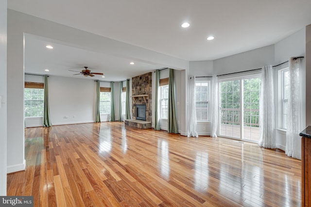 16309 Sandy Ridge Ct, Woodbridge, VA 22191 - unfurnished living room with light wood-type flooring, recessed lighting, a stone fireplace, ceiling fan, and baseboards