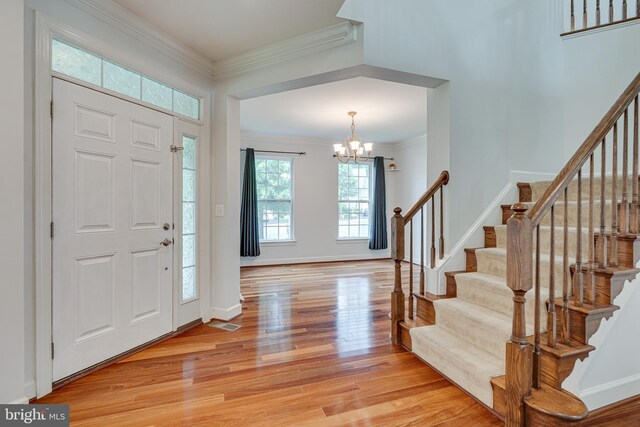16309 Sandy Ridge Ct, Woodbridge, VA 22191 - foyer featuring ornamental molding, light wood-style flooring, a chandelier, stairs, and baseboards
