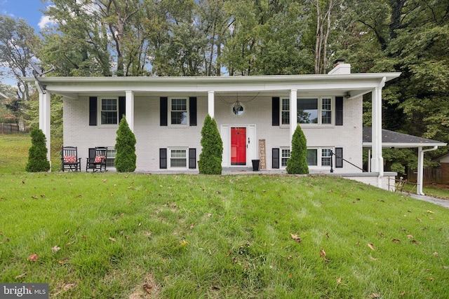 bi-level home featuring a front yard, brick siding, and a chimney