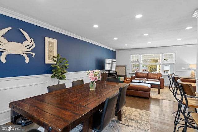 dining room featuring a wainscoted wall, ornamental molding, wood finished floors, and recessed lighting