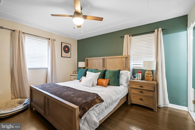 bedroom with dark wood-style floors, a ceiling fan, and baseboards