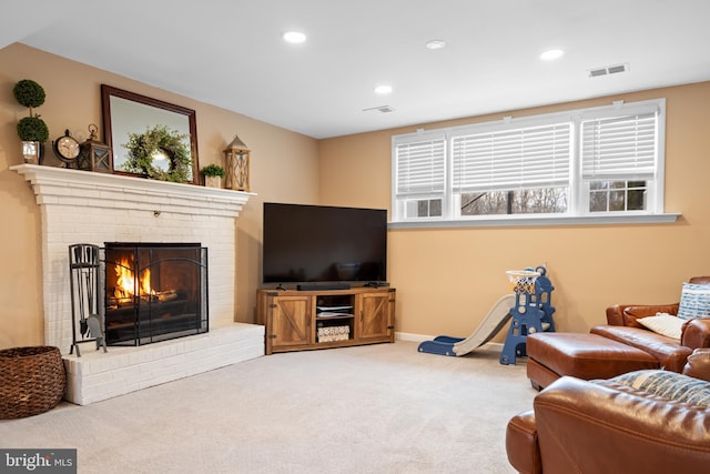 living area featuring a brick fireplace, carpet, visible vents, and recessed lighting