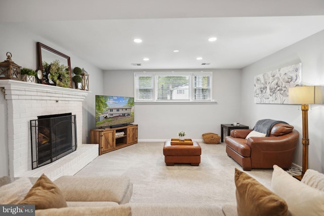 living area featuring visible vents, baseboards, carpet flooring, a brick fireplace, and recessed lighting