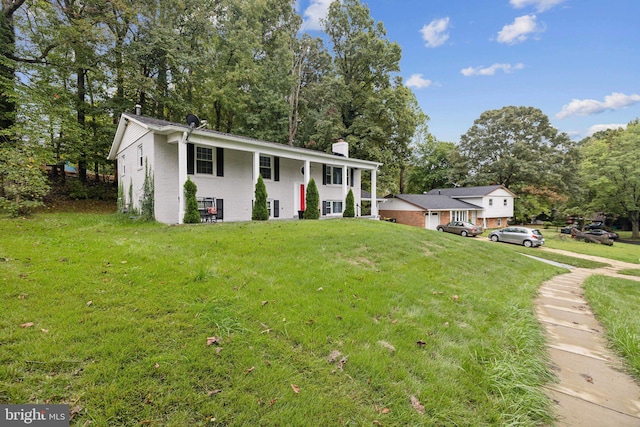 raised ranch featuring a chimney and a front yard