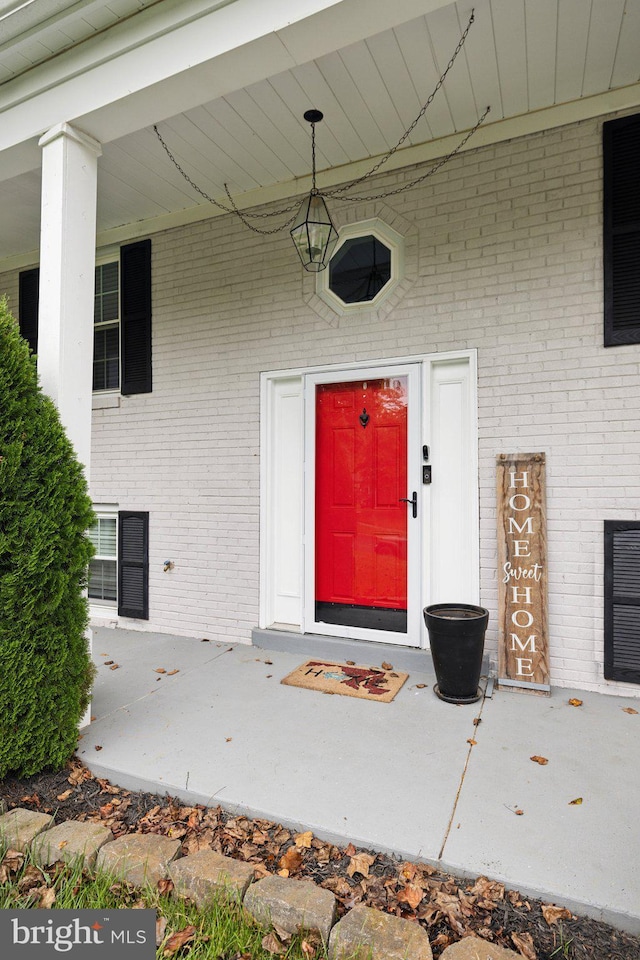 view of exterior entry with brick siding