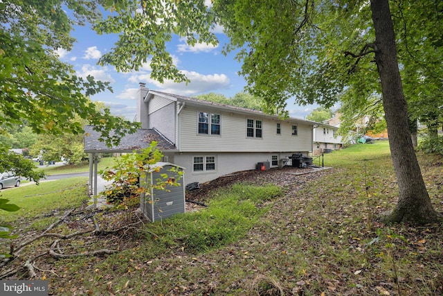 back of property with a yard and a chimney