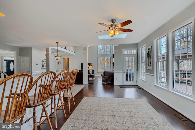 interior space with dark wood finished floors, visible vents, baseboards, and a ceiling fan