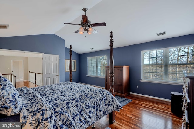 bedroom featuring lofted ceiling, wood finished floors, visible vents, and baseboards