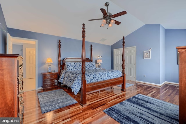 bedroom featuring ceiling fan, wood finished floors, baseboards, and vaulted ceiling