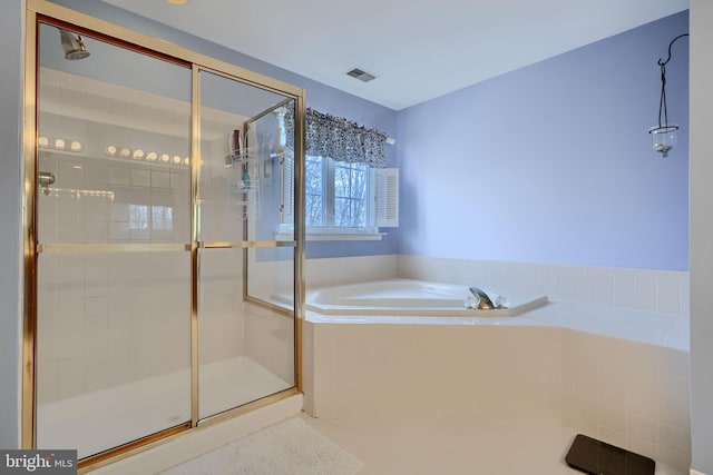 bathroom featuring visible vents, a garden tub, and a shower stall