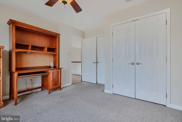 unfurnished office featuring baseboards, carpet floors, and ceiling fan