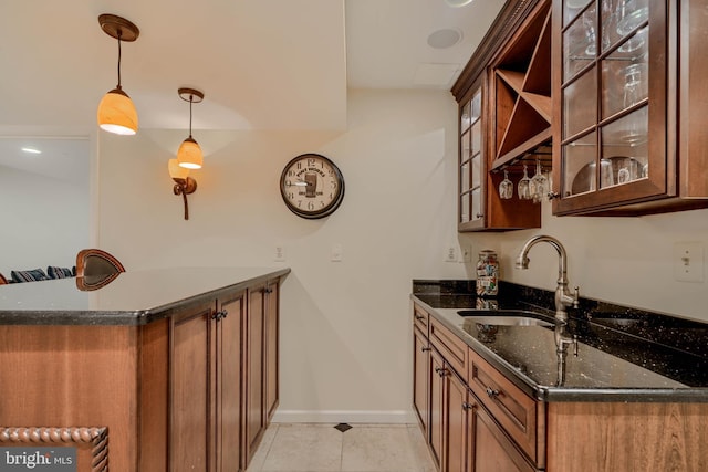 bar with light tile patterned floors, baseboards, a sink, indoor wet bar, and pendant lighting