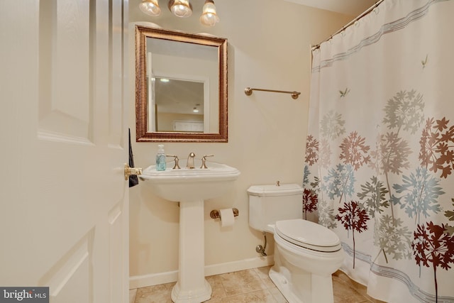 full bathroom with tile patterned floors, a shower with curtain, baseboards, and toilet