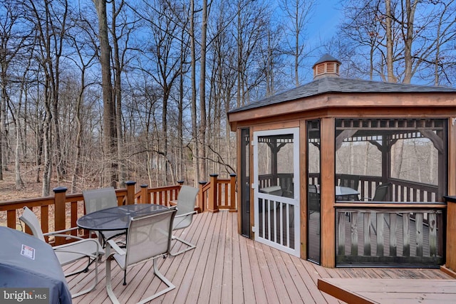 wooden deck featuring a gazebo and outdoor dining space