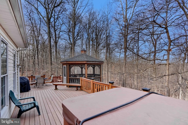 wooden deck featuring a gazebo, outdoor dining area, and a grill