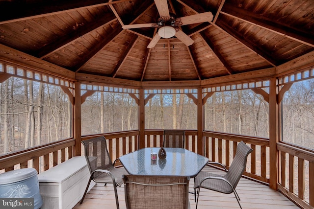 unfurnished sunroom with lofted ceiling with beams, wooden ceiling, and ceiling fan