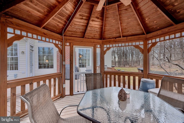 wooden terrace with a gazebo and outdoor dining area