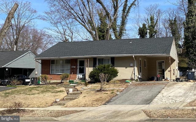 single story home with aphalt driveway, a shingled roof, brick siding, and a carport