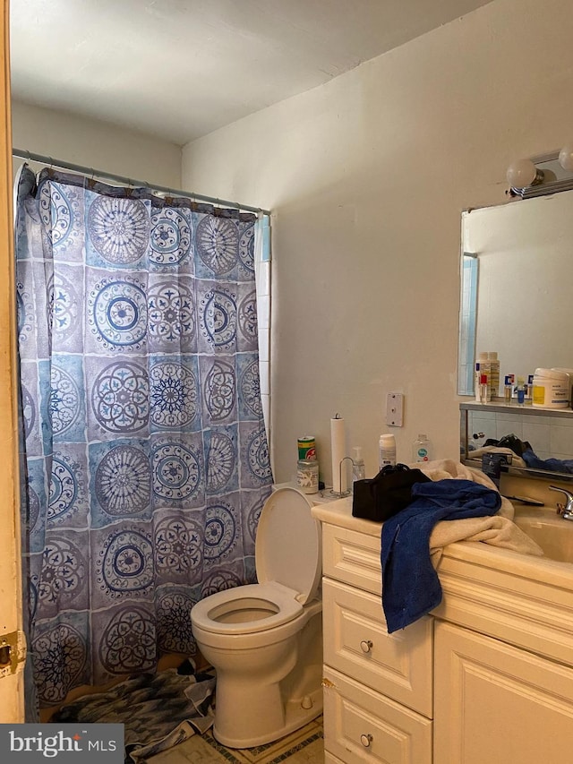 bathroom featuring curtained shower, toilet, and vanity