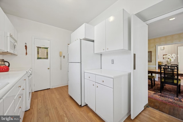 kitchen with light countertops, white appliances, light wood-type flooring, and white cabinetry