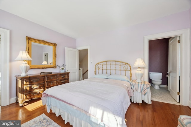 bedroom with baseboards and wood finished floors