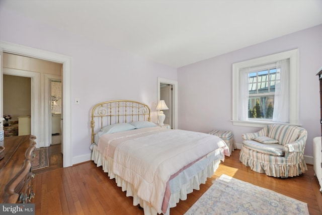 bedroom with baseboards and wood finished floors