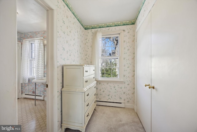 hallway with a baseboard radiator, light carpet, and wallpapered walls