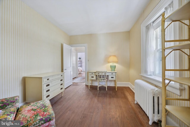 sitting room featuring radiator heating unit, baseboards, and wood finished floors