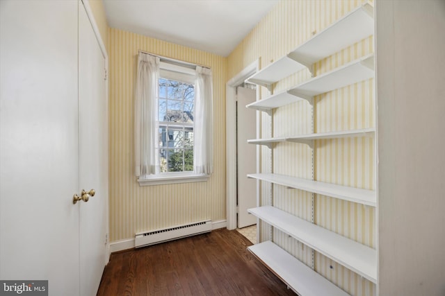 interior space featuring a baseboard heating unit and wood finished floors